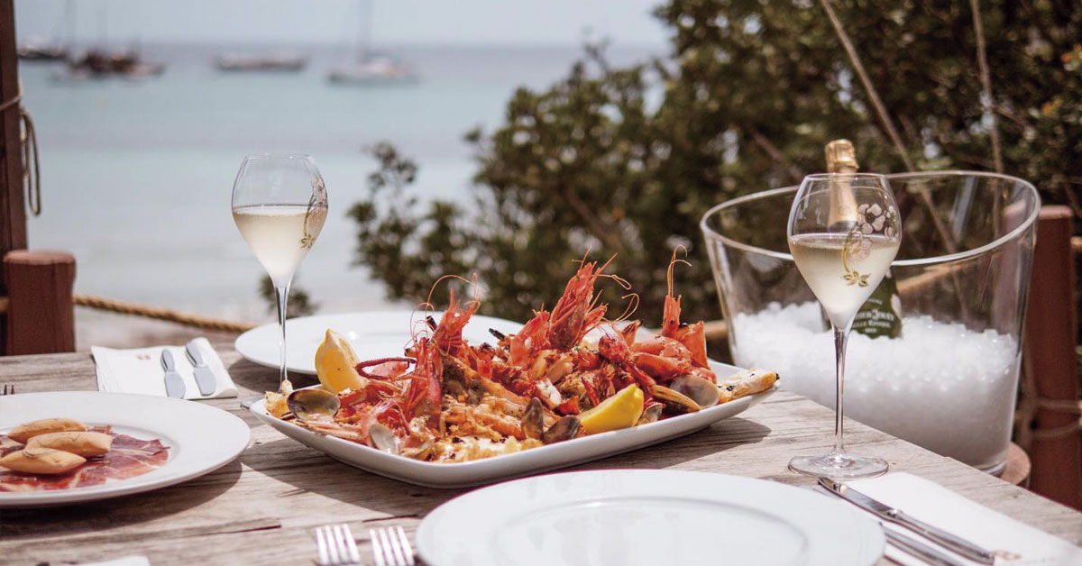 plato de marisco y copas de vino en beso beach